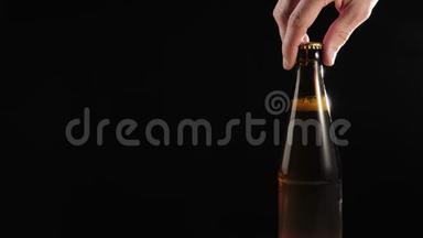 新<strong>鲜啤酒</strong>。 手拿一个棕色的瓶子和美味的工艺<strong>啤酒</strong>从木桌上黑色背景。 冷<strong>鲜啤酒</strong>